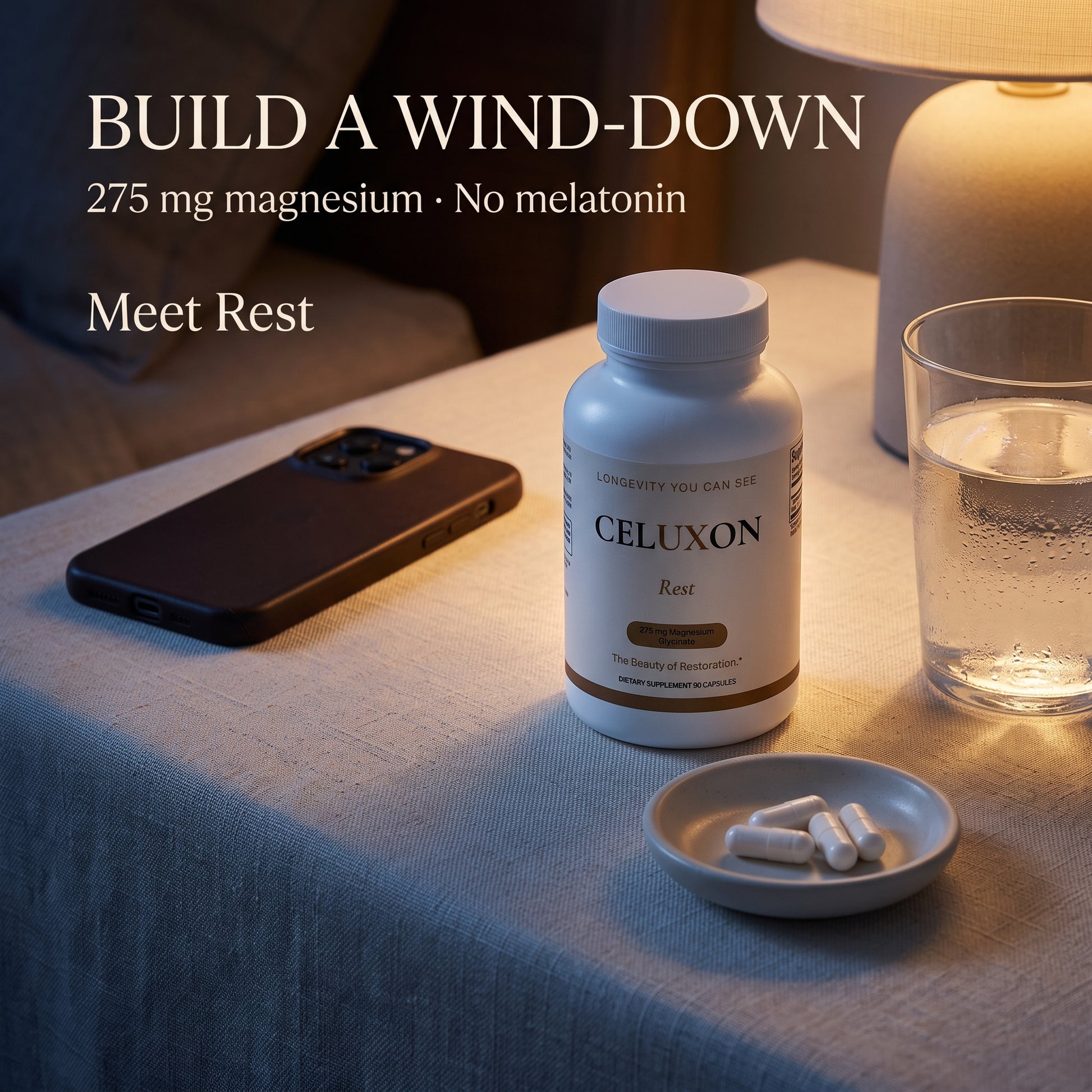 A bottle of CELUXON Rest magnesium supplement sits on a table next to a glass of water, a smartphone, and a small dish of capsules under warm indoor lighting. Text on the image reads 'BUILD A WIND-DOWN 275 mg magnesium • No melatonin Meet Rest'.