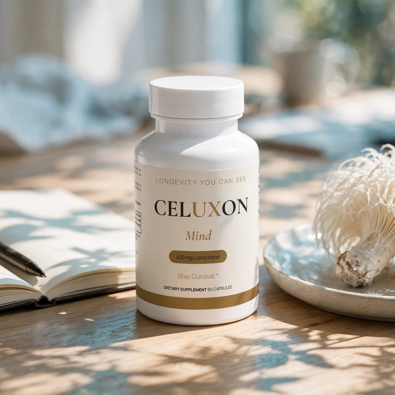 A white bottle of CELUXON Mind dietary supplement capsules sits on a wooden table in a warm, sunlit setting. The scene is styled with an open notebook and pen on the left and a plate with dried mushrooms on the right, creating a cozy, natural aesthetic.